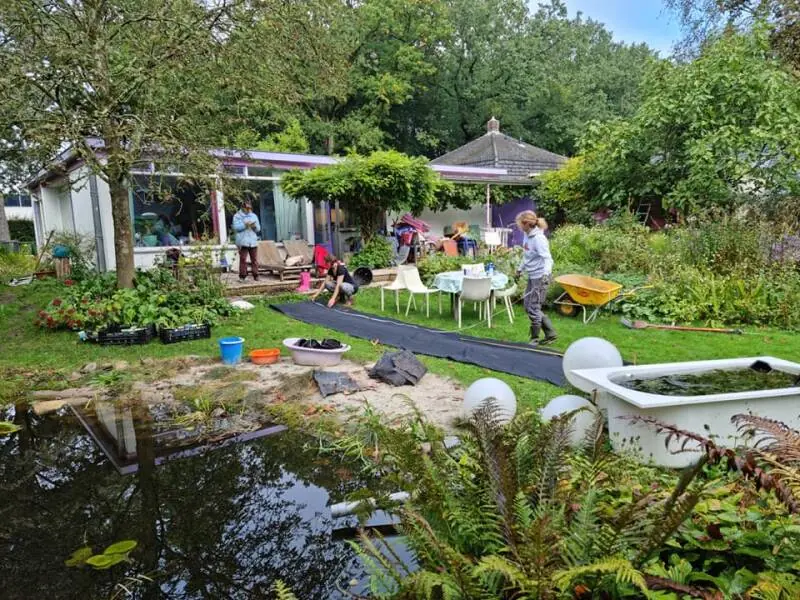 Bezoekers in de voorbeeldtuin van Eco-Care bij de Kaardebol in Zutphen
